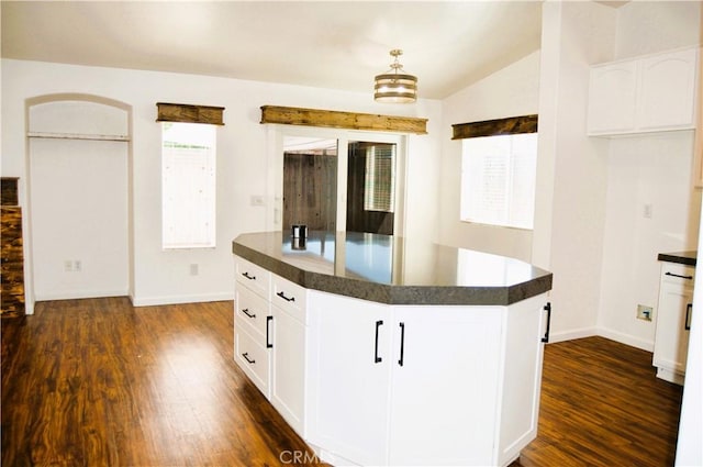 kitchen featuring dark wood-style flooring, white cabinetry, baseboards, and dark countertops