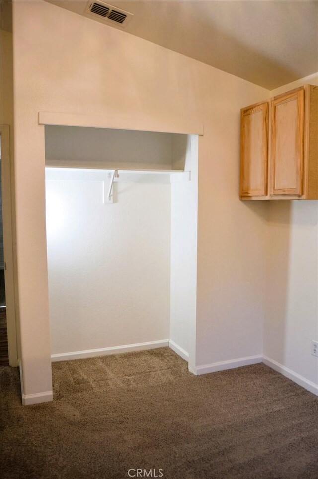 carpeted spare room featuring visible vents and baseboards