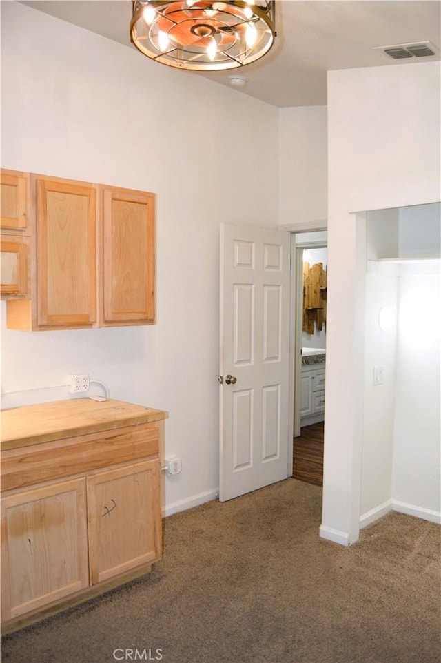 interior space featuring visible vents, baseboards, a notable chandelier, vanity, and carpet flooring