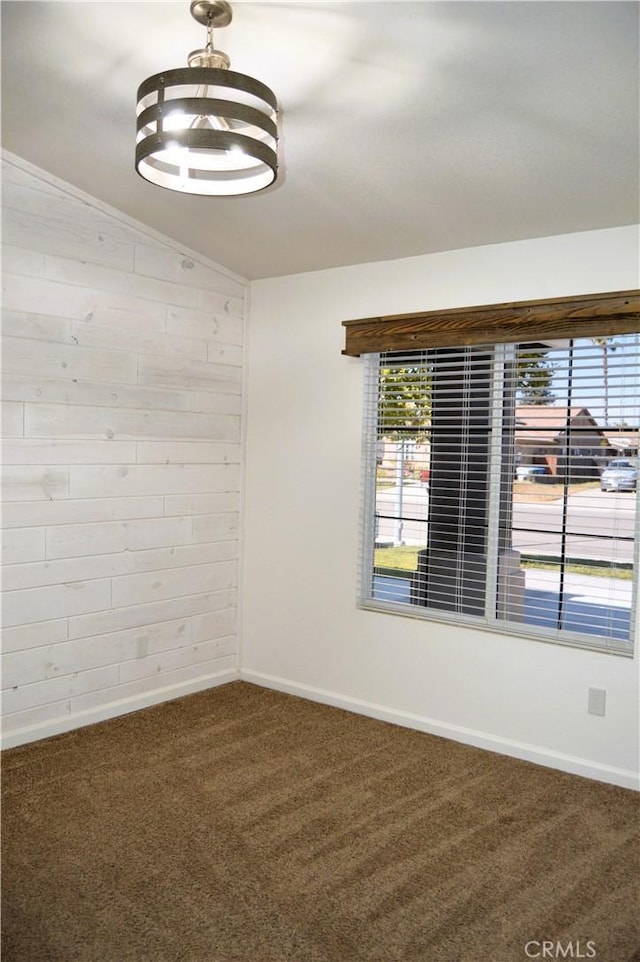 unfurnished room featuring a healthy amount of sunlight, carpet flooring, baseboards, and lofted ceiling