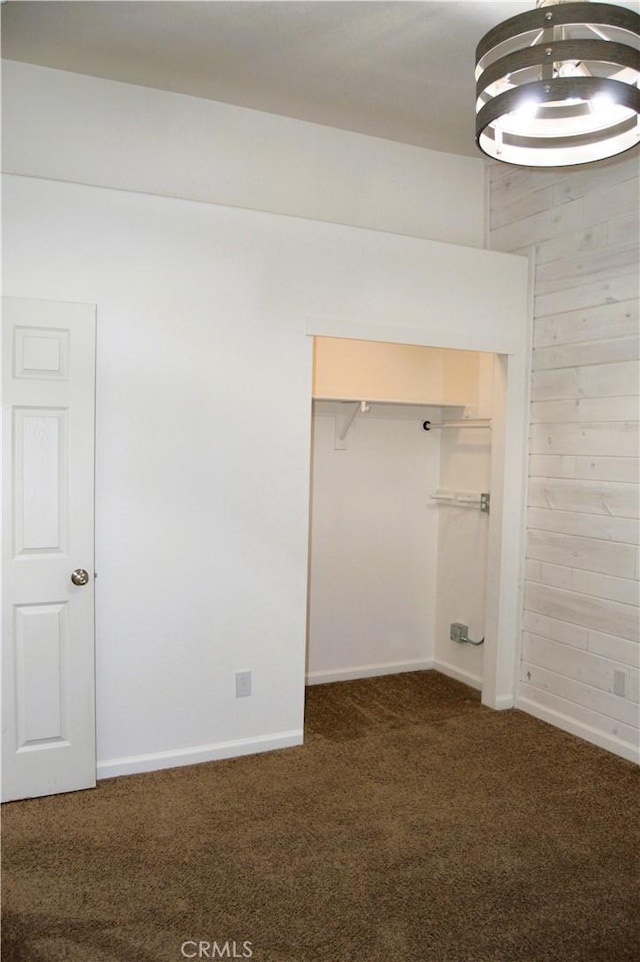 unfurnished bedroom with a closet, baseboards, and carpet floors
