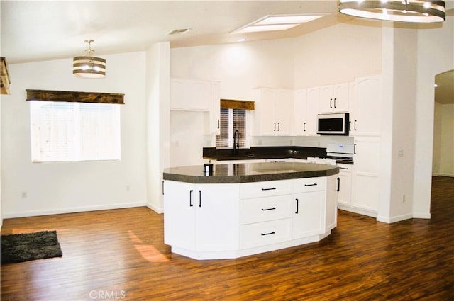 kitchen with dark wood-style flooring, white cabinetry, and dark countertops
