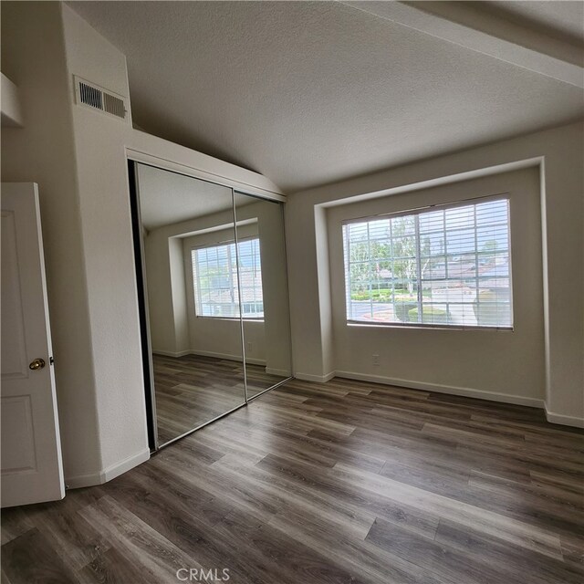 907 W Arrow, Claremont, CA 91711 - unfurnished bedroom with vaulted ceiling, visible vents, dark wood-type flooring, a closet, and a textured ceiling