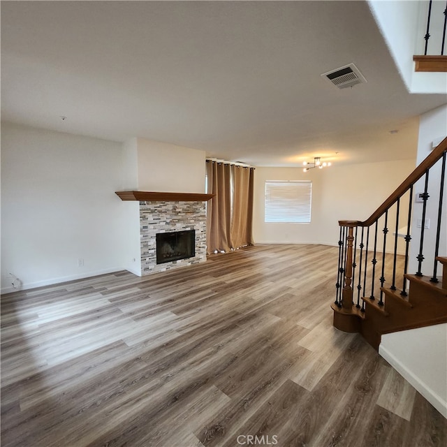 907 W Arrow, Claremont, CA 91711 - unfurnished living room with stairway, wood finished floors, visible vents, and a stone fireplace
