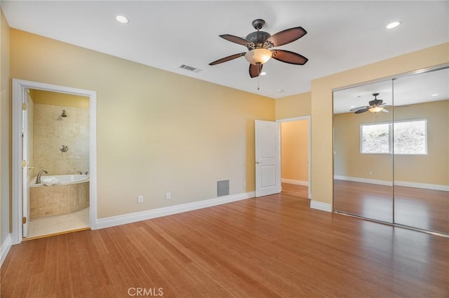 unfurnished bedroom with baseboards, a closet, visible vents, and wood finished floors