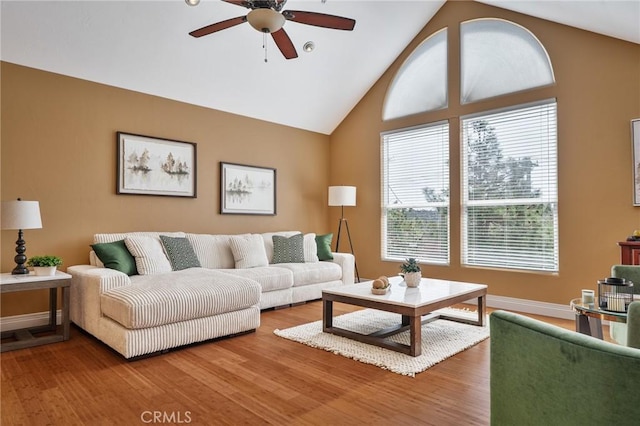 living room featuring baseboards, high vaulted ceiling, ceiling fan, and wood finished floors