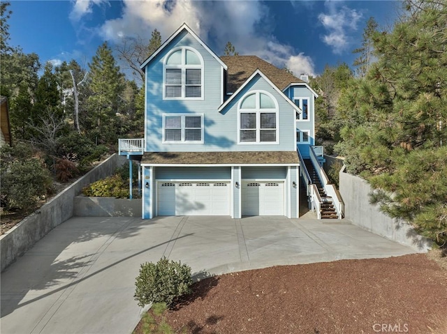27732 N Bay Rd, Lake Arrowhead, CA 92352 - view of side of home featuring concrete driveway, a garage, stairs, and a shingled roof