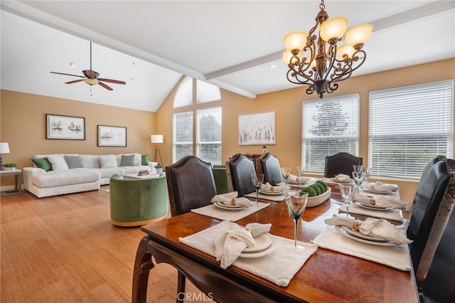 dining room with light wood-style floors, ceiling fan with notable chandelier, and vaulted ceiling with beams