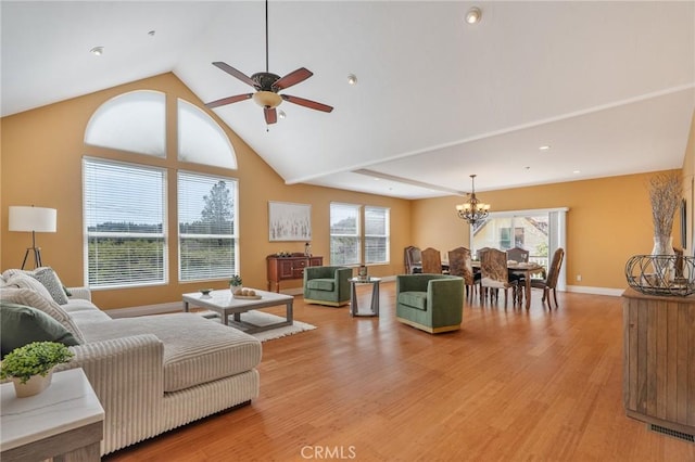 living room featuring light wood-style flooring, ceiling fan with notable chandelier, a healthy amount of sunlight, and visible vents