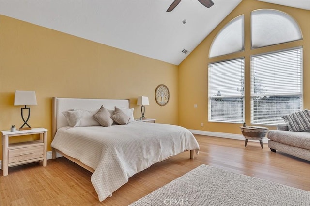 bedroom with high vaulted ceiling, visible vents, baseboards, ceiling fan, and light wood-style floors
