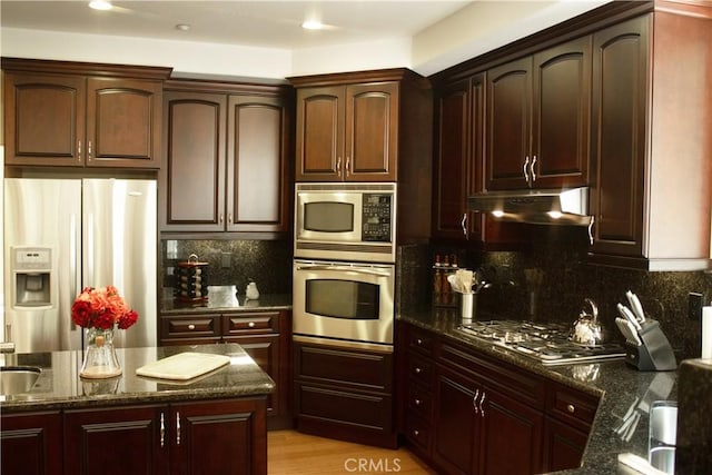 27732 N Bay Rd, Lake Arrowhead, CA 92352 - kitchen featuring stainless steel appliances, under cabinet range hood, dark stone counters, tasteful backsplash, and recessed lighting