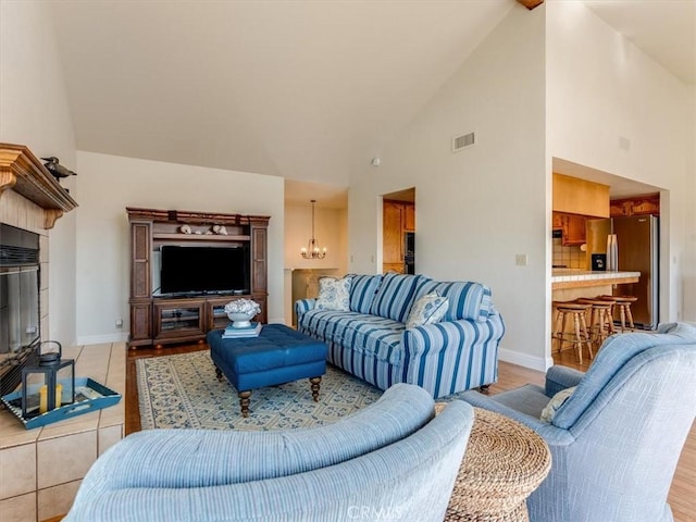 101 Searidge Ct, Pismo Beach, CA 93449 - living room featuring high vaulted ceiling, a chandelier, a tile fireplace, and light wood finished floors