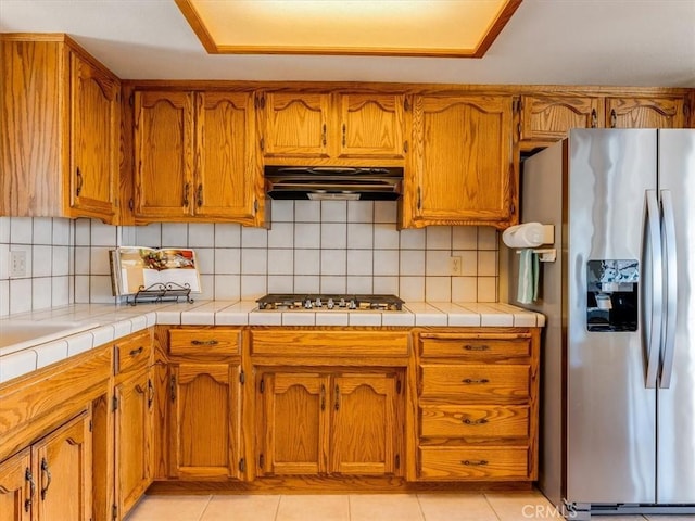 101 Searidge Ct, Pismo Beach, CA 93449 - kitchen featuring stainless steel refrigerator with ice dispenser, under cabinet range hood, brown cabinetry, and backsplash