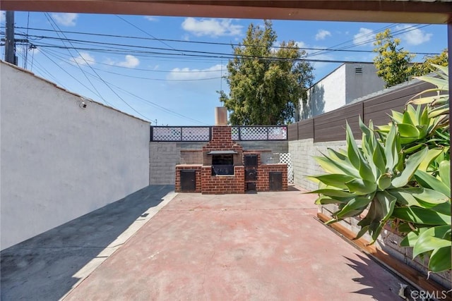 view of patio / terrace featuring fence and a fireplace