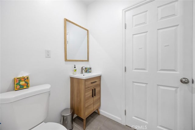 bathroom featuring vanity, tile patterned flooring, baseboards, and toilet