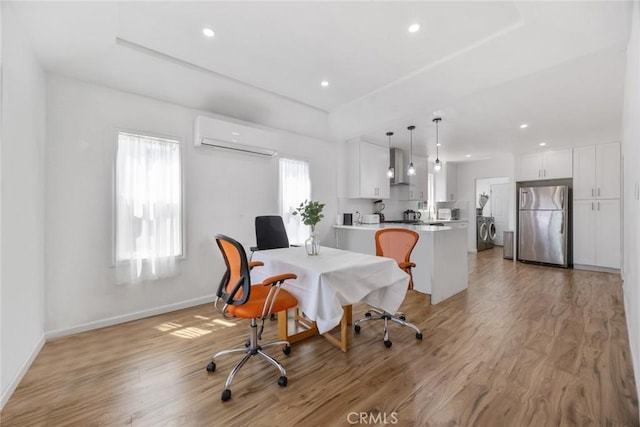 dining space with light wood-style floors, baseboards, and a wall unit AC