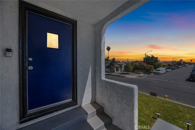 exterior entry at dusk with stucco siding