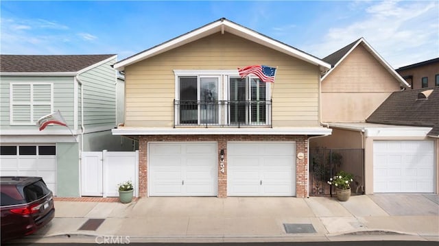 townhome / multi-family property with a garage, brick siding, fence, and a gate