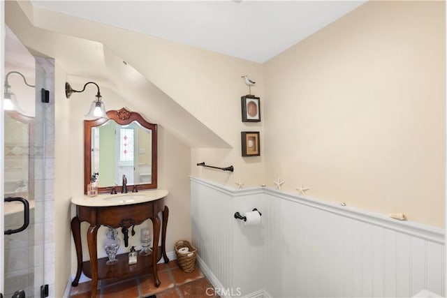 bathroom with a shower stall, vanity, and wainscoting