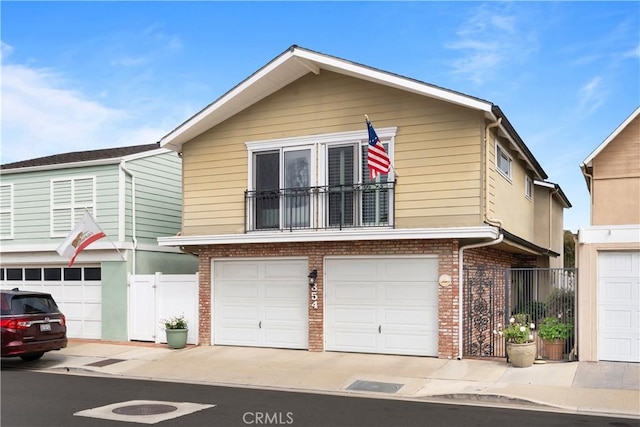 view of front of property featuring an attached garage, driveway, fence, and brick siding