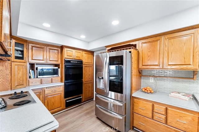 4811 Sharon Dr, La Palma, CA 90623 - kitchen with appliances with stainless steel finishes, a warming drawer, light countertops, backsplash, and light wood-style floors