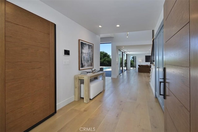 corridor with recessed lighting, light wood finished floors, and baseboards