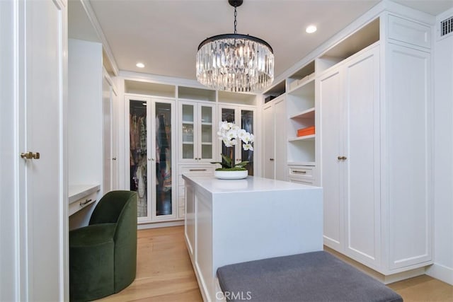 spacious closet featuring a notable chandelier, light wood-style flooring, and visible vents