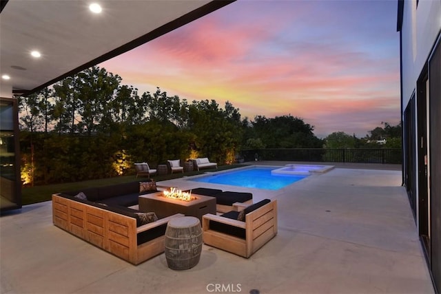 pool at dusk with an outdoor living space with a fire pit, a patio area, and a fenced in pool