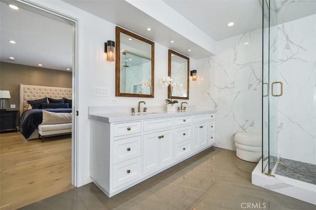 ensuite bathroom with a sink, ensuite bathroom, a marble finish shower, and double vanity