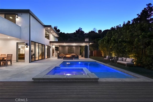 view of swimming pool featuring a pool with connected hot tub, an outdoor living space, and a wooden deck