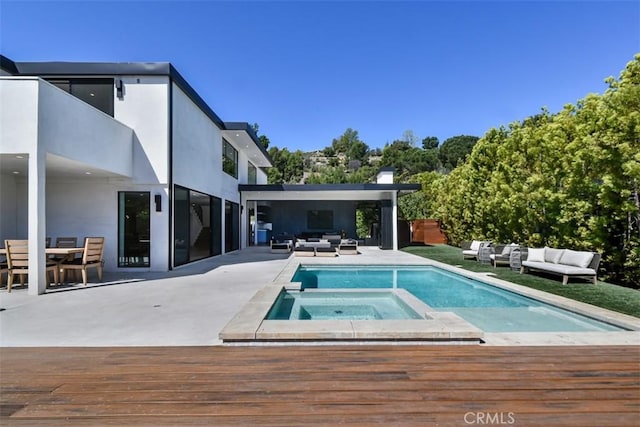 view of swimming pool featuring a pool with connected hot tub, a deck, outdoor dining area, and an outdoor hangout area