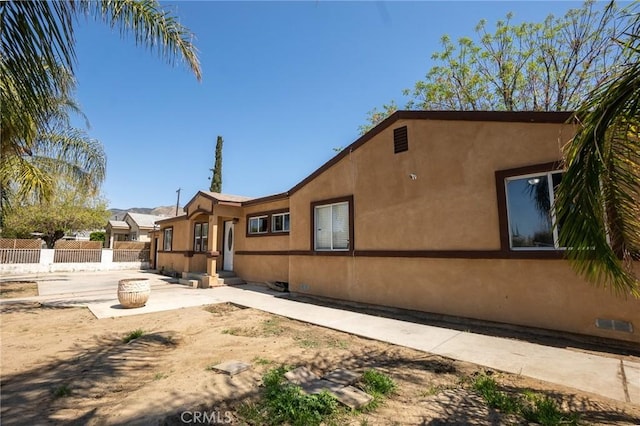 exterior space featuring a patio, stucco siding, and fence