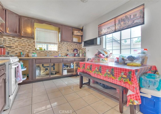 kitchen featuring tasteful backsplash, light tile patterned floors, light countertops, and white range with gas stovetop