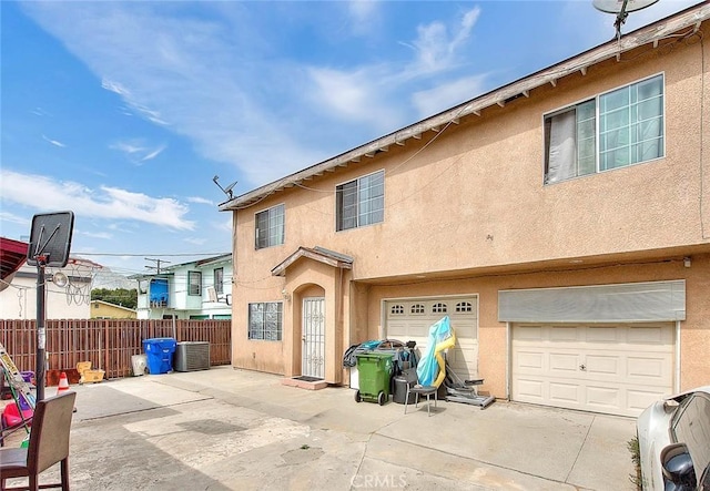 back of house featuring central air condition unit, a patio area, stucco siding, and fence