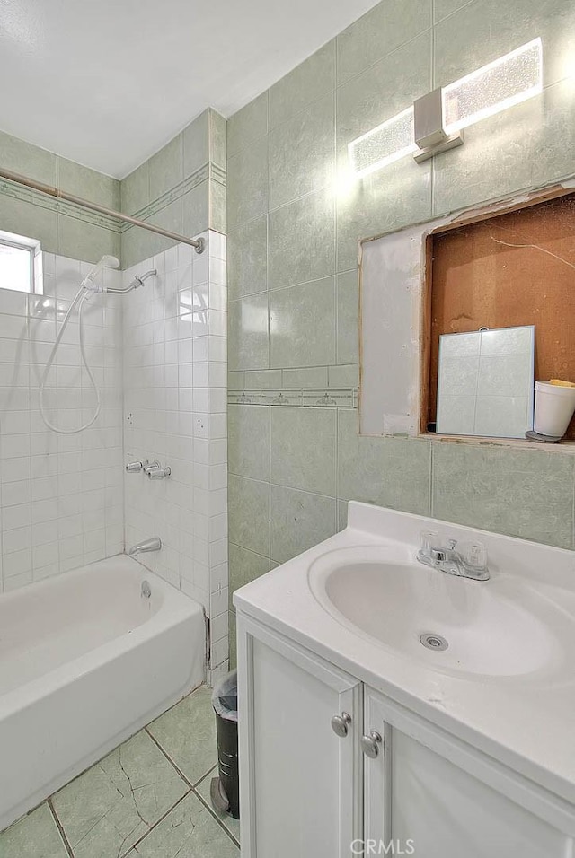 full bathroom featuring tile walls, vanity, and bathing tub / shower combination