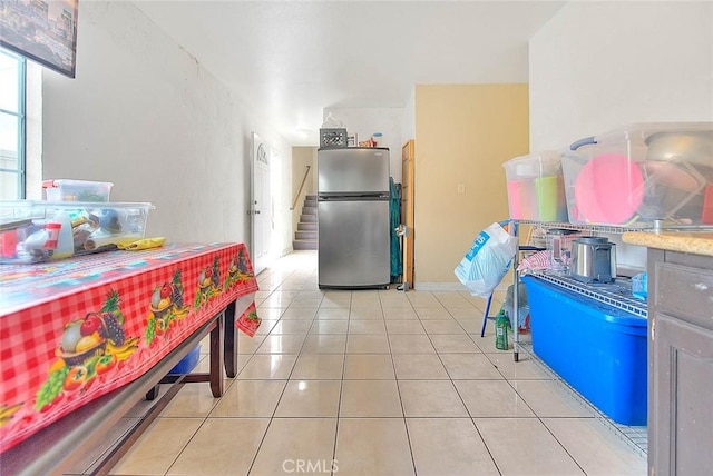 kitchen with light tile patterned floors and freestanding refrigerator
