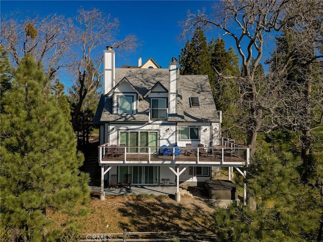 27684 St Bernard Ln, Lake Arrowhead, CA 92352 - rear view of house with a chimney, a hot tub, a patio area, and a deck