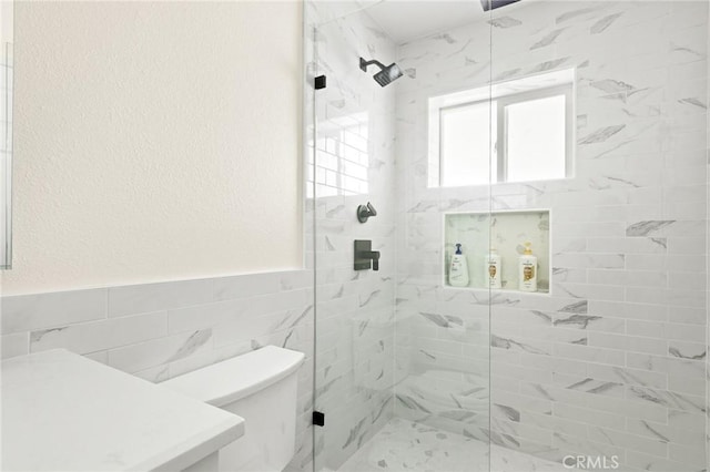 27684 St Bernard Ln, Lake Arrowhead, CA 92352 - bathroom with tile walls, wainscoting, a shower stall, toilet, and a textured wall
