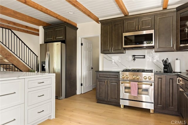 27684 St Bernard Ln, Lake Arrowhead, CA 92352 - kitchen with decorative backsplash, dark brown cabinetry, beamed ceiling, light wood-style floors, and stainless steel appliances