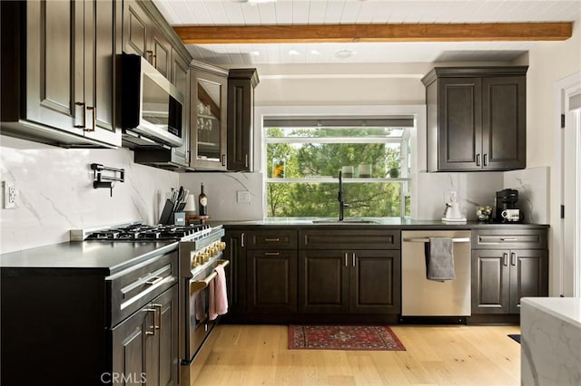 27684 St Bernard Ln, Lake Arrowhead, CA 92352 - kitchen featuring appliances with stainless steel finishes, beam ceiling, a sink, light wood-style flooring, and decorative backsplash