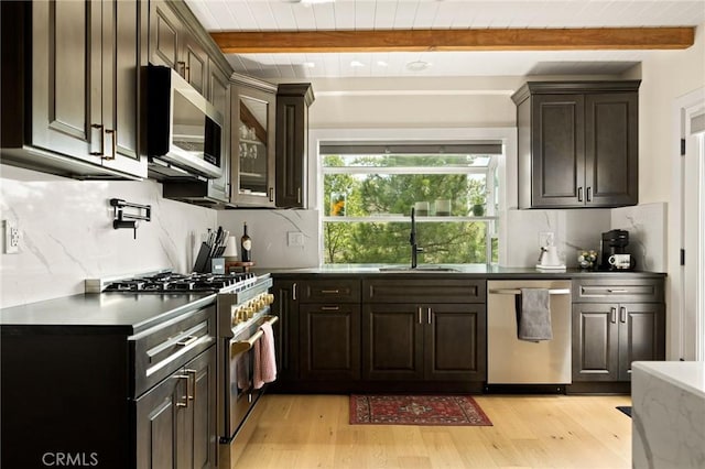 27684 St Bernard Ln, Lake Arrowhead, CA 92352 - kitchen with appliances with stainless steel finishes, beam ceiling, light wood finished floors, and decorative backsplash