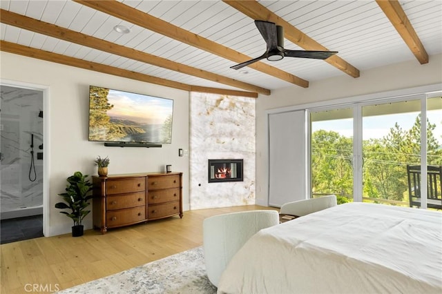 27684 St Bernard Ln, Lake Arrowhead, CA 92352 - bedroom featuring a glass covered fireplace, wood finished floors, beamed ceiling, connected bathroom, and wood ceiling