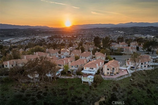 aerial view at dusk featuring a residential view and a mountain view