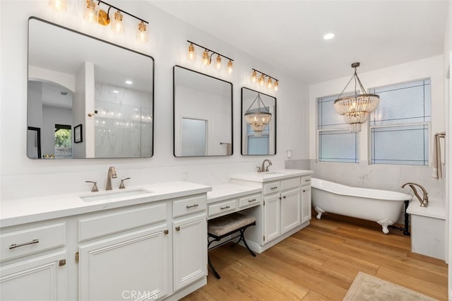 37549 Windsor Ct, Murrieta, CA 92562 - bathroom featuring a freestanding tub, vanity, wood finished floors, walk in shower, and a notable chandelier