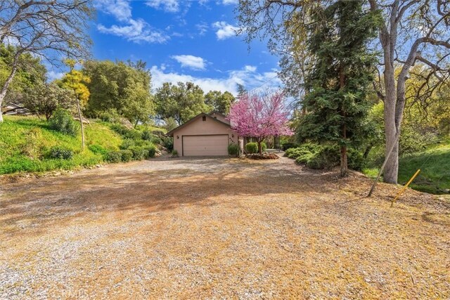 42852 Badger Circle Dr, Coarsegold, CA 93614 - view of front of property featuring stucco siding, an attached garage, and dirt driveway