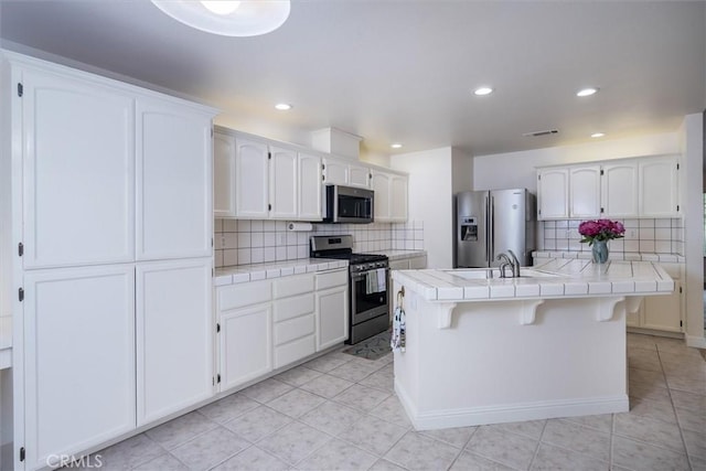 42852 Badger Circle Dr, Coarsegold, CA 93614 - kitchen with tasteful backsplash, appliances with stainless steel finishes, a sink, and tile counters