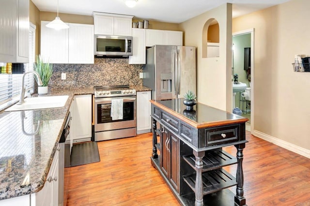 5362 Lake Murray Blvd, La Mesa, CA 91942 - kitchen featuring white cabinets, light wood-style flooring, a sink, decorative backsplash, and appliances with stainless steel finishes