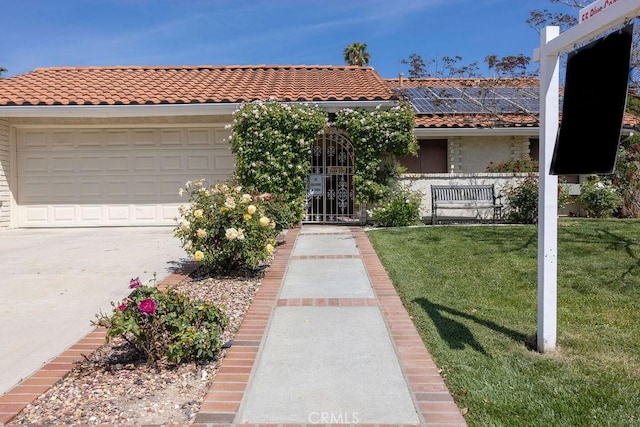 1130 Carob Ct, Hemet, CA 92545 - mediterranean / spanish home featuring concrete driveway, solar panels, a front yard, a tiled roof, and a garage