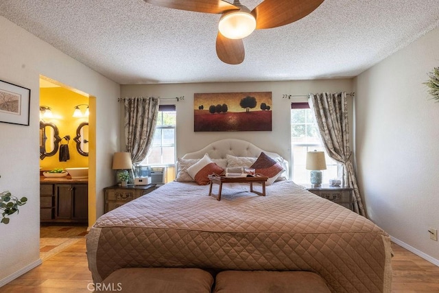 1130 Carob Ct, Hemet, CA 92545 - bedroom with multiple windows, light wood-type flooring, connected bathroom, a textured ceiling, and a ceiling fan