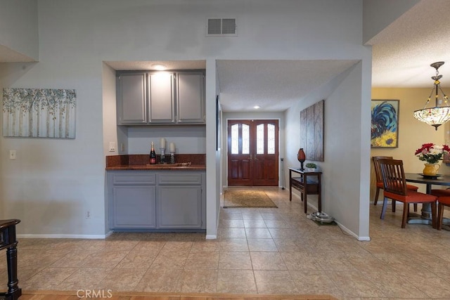 1130 Carob Ct, Hemet, CA 92545 - kitchen featuring gray cabinetry, dark countertops, light tile patterned flooring, and pendant lighting
